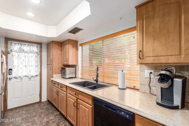 a kitchen with stainless steel appliances granite countertop a sink and a wooden floors