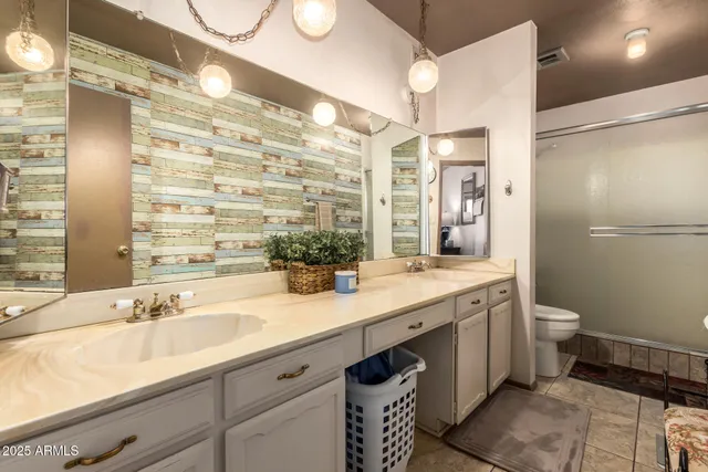 a bathroom with a double vanity sink toilet and shower