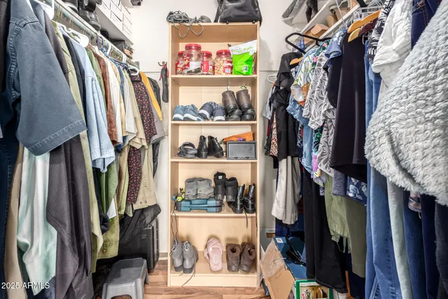 a view of walk in closet with clothes and shoes