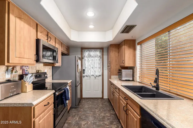 a kitchen with stainless steel appliances granite countertop a sink stove and refrigerator