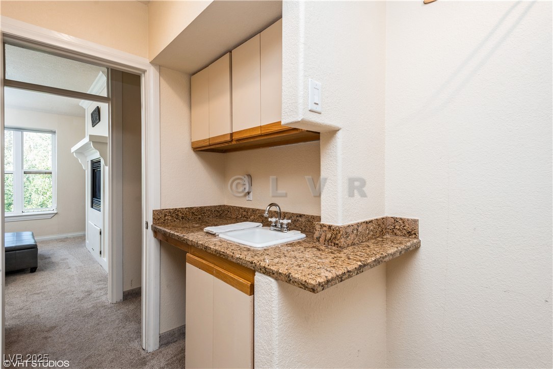 223 Hunter Ridge Drive, Unit 300 Brian Head, UT 84719 - Photo 19 of 48 Kitchen featuring stone countertops, baseboards, light carpet, and a sink