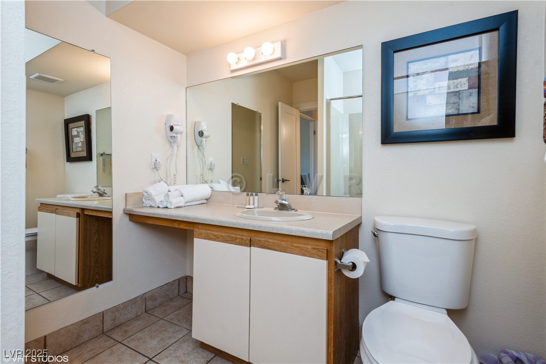 223 Hunter Ridge Drive, Unit 300 Brian Head, UT 84719 - Photo 24 of 48 Bathroom with a shower with shower door, toilet, visible vents, tile patterned flooring, and vanity