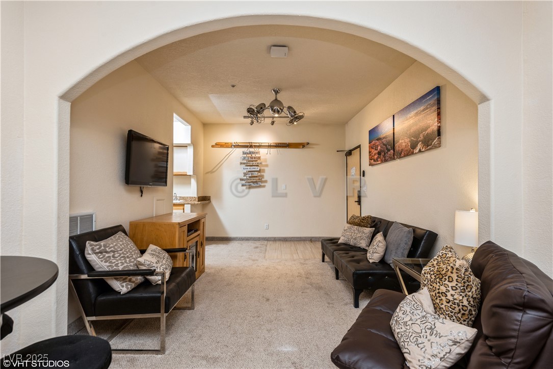 223 Hunter Ridge Drive, Unit 300 Brian Head, UT 84719 - Photo 5 of 48 Living room featuring arched walkways, carpet, and visible vents