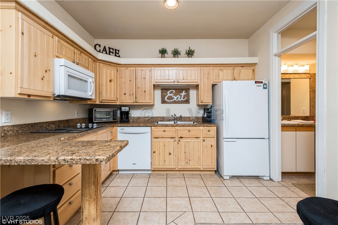 223 Hunter Ridge Drive, Unit 300 Brian Head, UT 84719 - Photo 9 of 48 Kitchen featuring light brown cabinets, white appliances, and light tile patterned floors