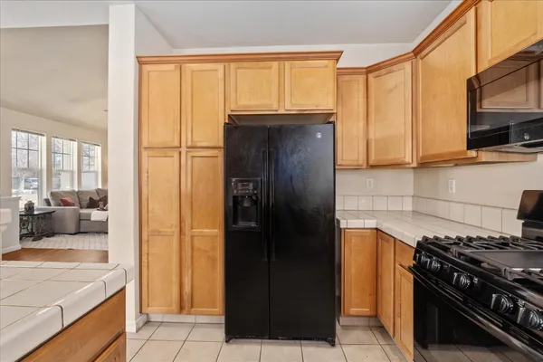 a kitchen with a stove a refrigerator and cabinets