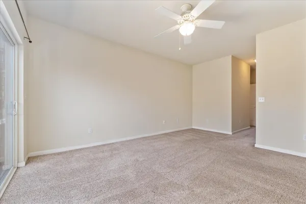an empty room with closet and a ceiling fan