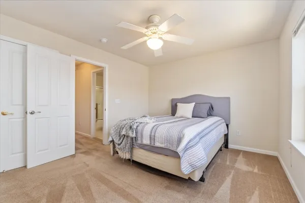 a spacious bedroom with a bed and a chandelier