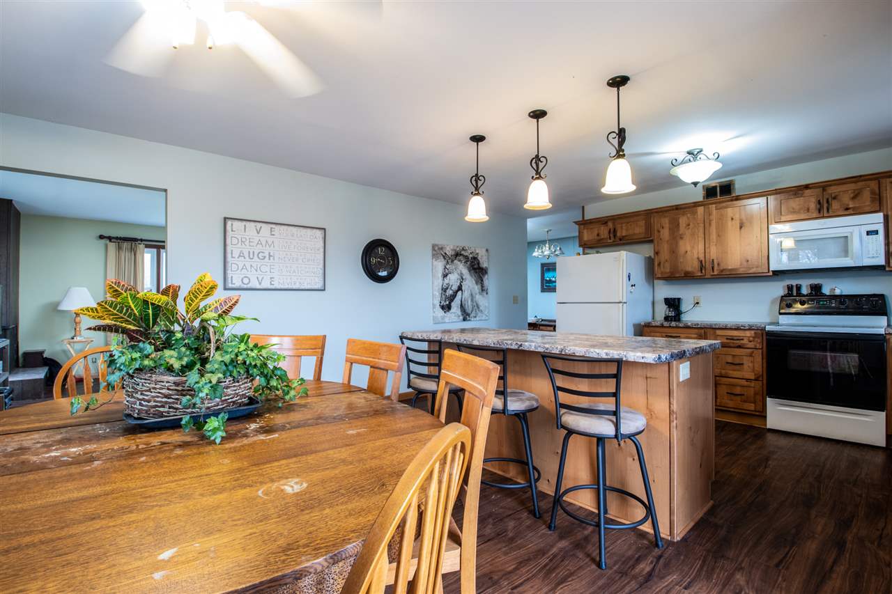 14500 Saunders Road Pecatonica, IL 61063 - Photo 11 of 19 a kitchen with stainless steel appliances kitchen island granite countertop a table chairs sink and cabinets