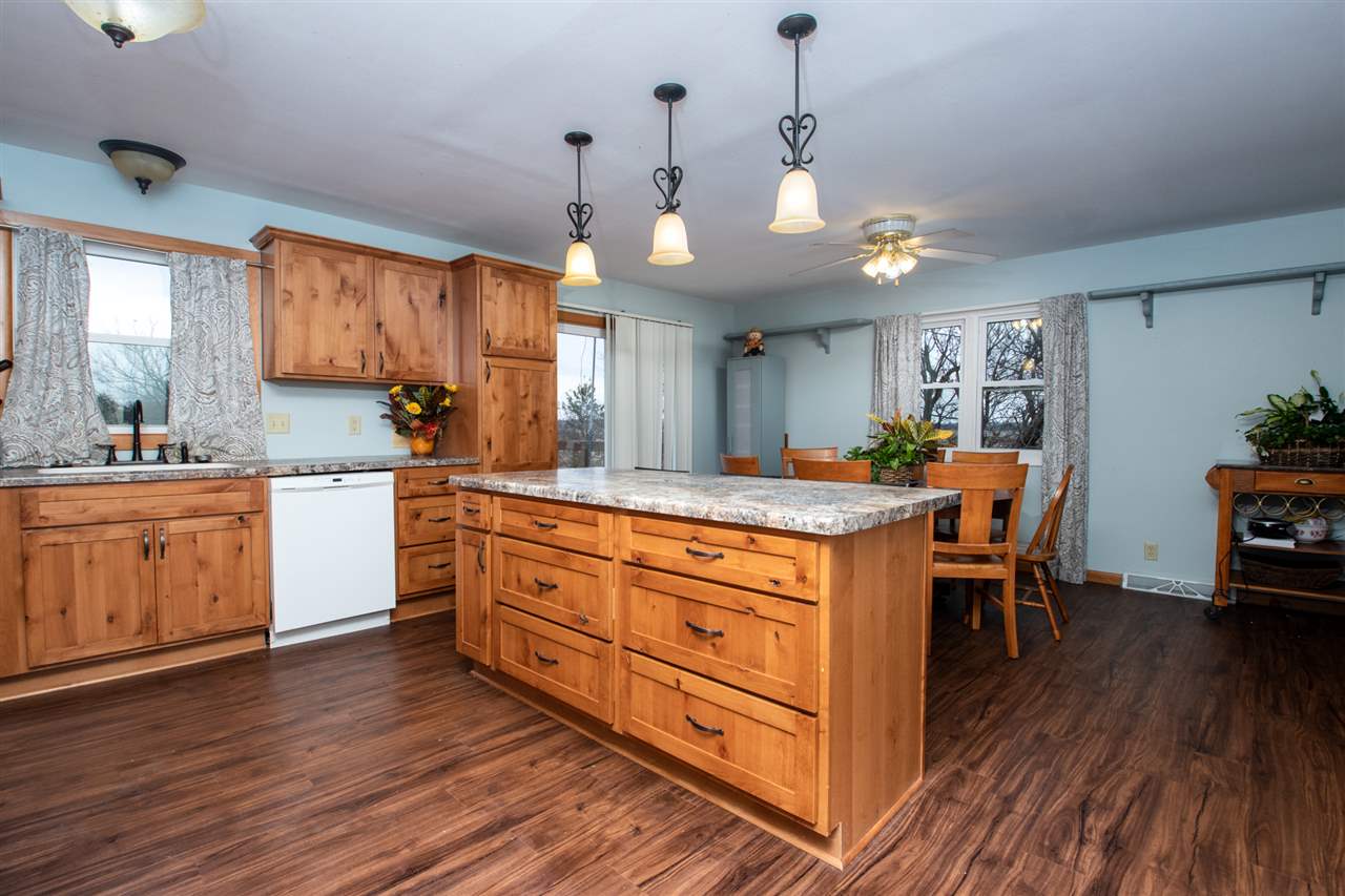 14500 Saunders Road Pecatonica, IL 61063 - Photo 8 of 19 a kitchen with stainless steel appliances granite countertop wooden floors and white cabinets