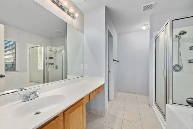 a spacious bathroom with a shower sink and mirror