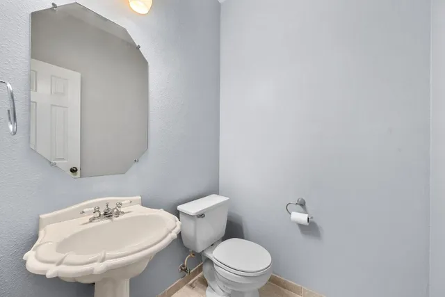 a bathroom with a sink mirror and toilet