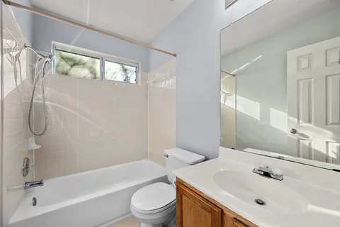 a bathroom with a bathtub shower sink vanity and toilet