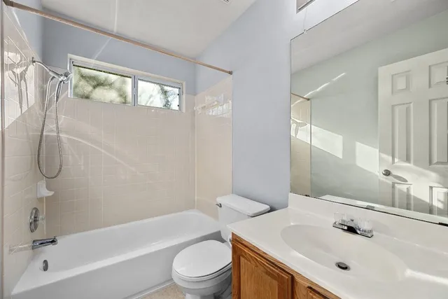a bathroom with a bathtub shower sink vanity and toilet