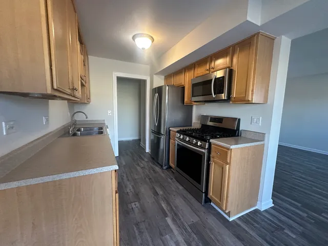 a kitchen with stainless steel appliances granite countertop a stove a sink and a refrigerator