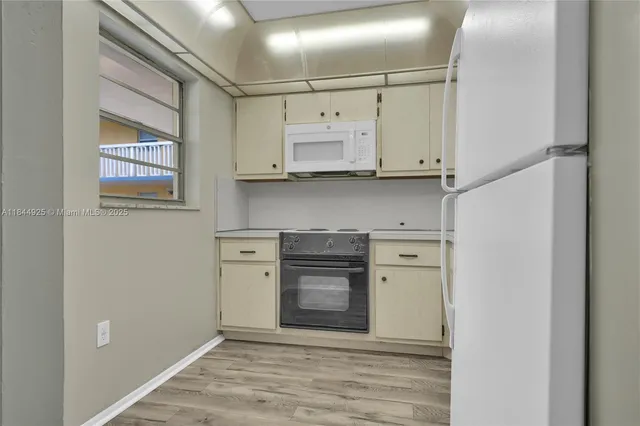 a kitchen with white cabinets stainless steel appliances and sink