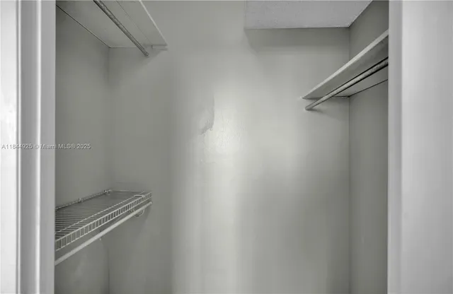 a view of a hallway with wooden floor and a bathroom