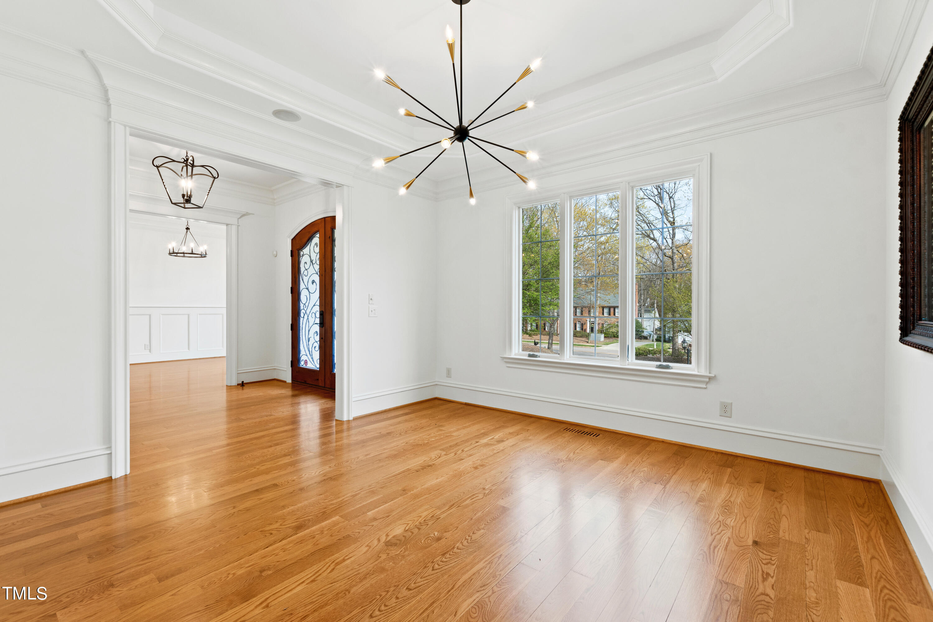8108 Harps Mill Road Raleigh, NC 27615 - Photo 8 of 64 a view of an empty room with window and wooden floor