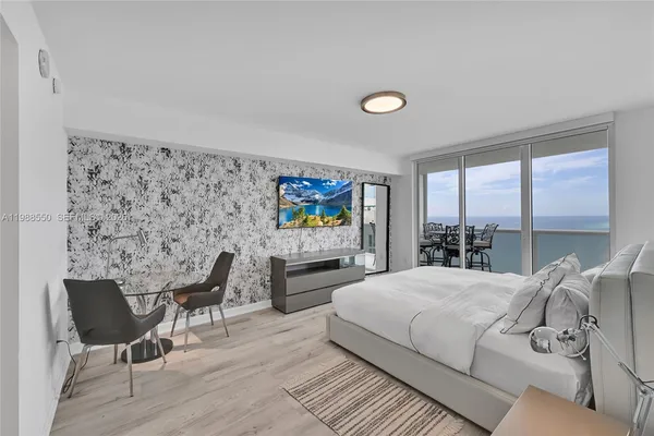 a bedroom with a bed and large windows