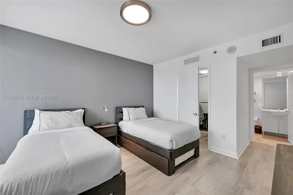 a bedroom with two beds and white walls