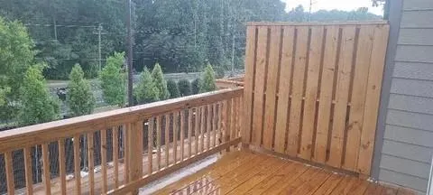 a balcony with wooden floor and fence