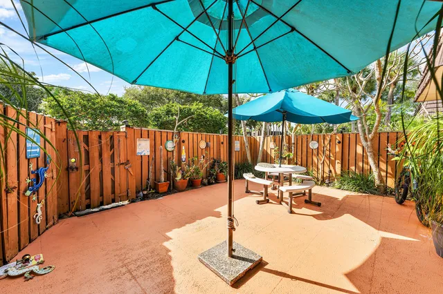 a view of a patio with a table and chairs under an umbrella