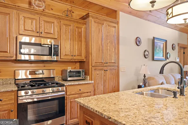 a kitchen with stainless steel appliances granite countertop a stove a sink and a refrigerator