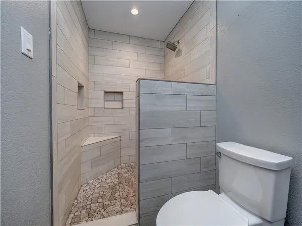 a bathroom with a toilet and a shower