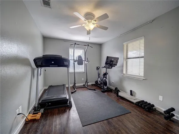 a room with gym equipment and wooden floor