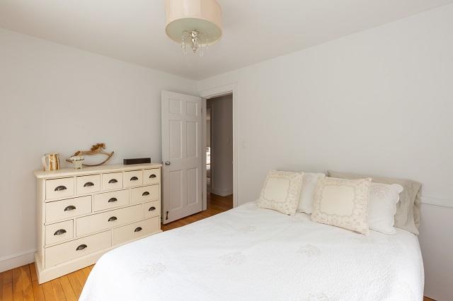 56 Nickerson Road Cotuit, MA 02635 - Photo 14 of 36 a bedroom with a bed and cabinets