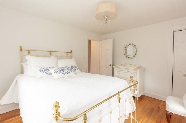 56 Nickerson Road Cotuit, MA 02635 - Photo 17 of 36 a bedroom with a bed and a chandelier