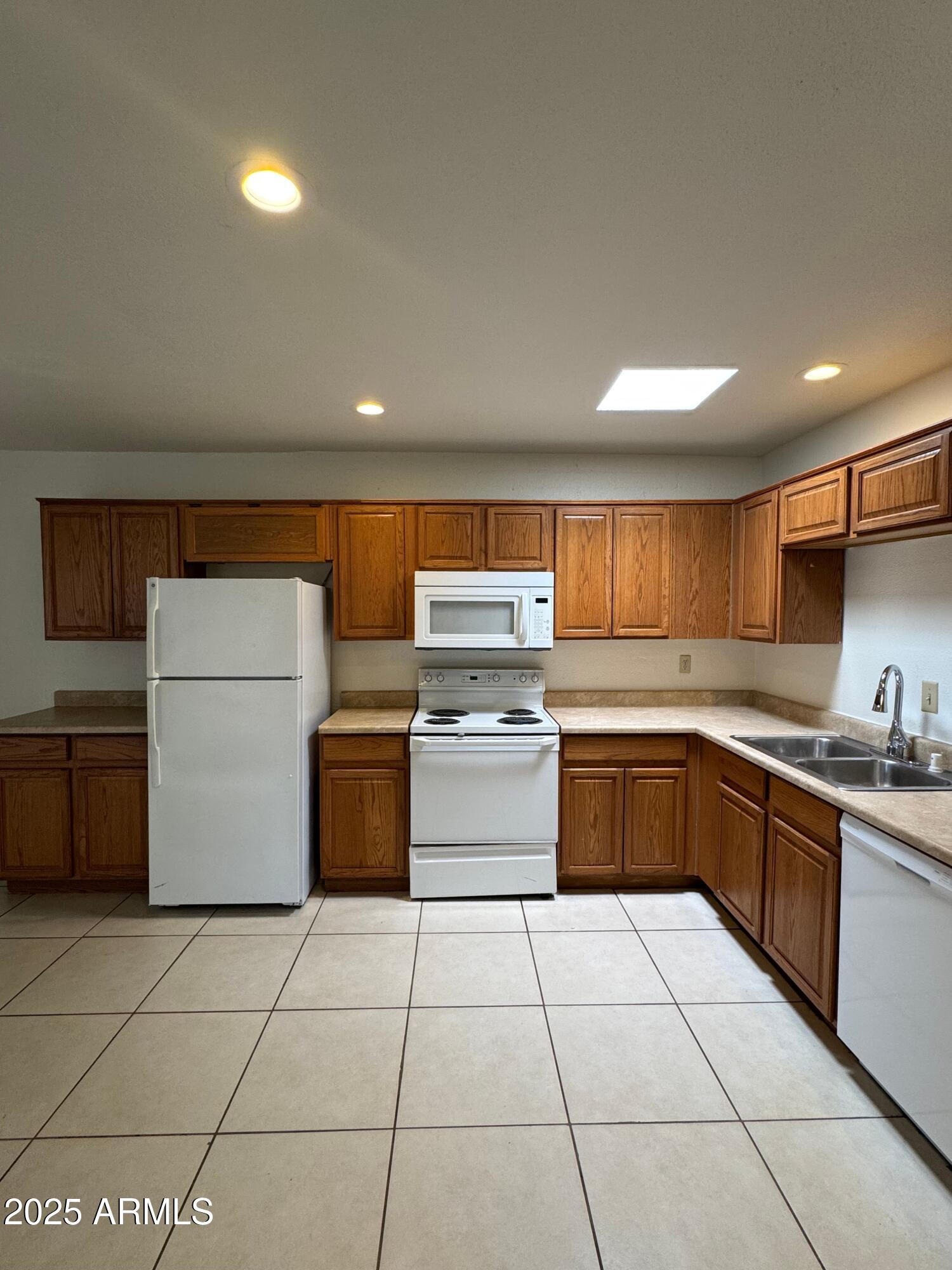 930 South Dobson Road, Unit 23 Mesa, AZ 85202 - Photo 3 of 13 a kitchen with stainless steel appliances granite countertop a stove a sink and a refrigerator