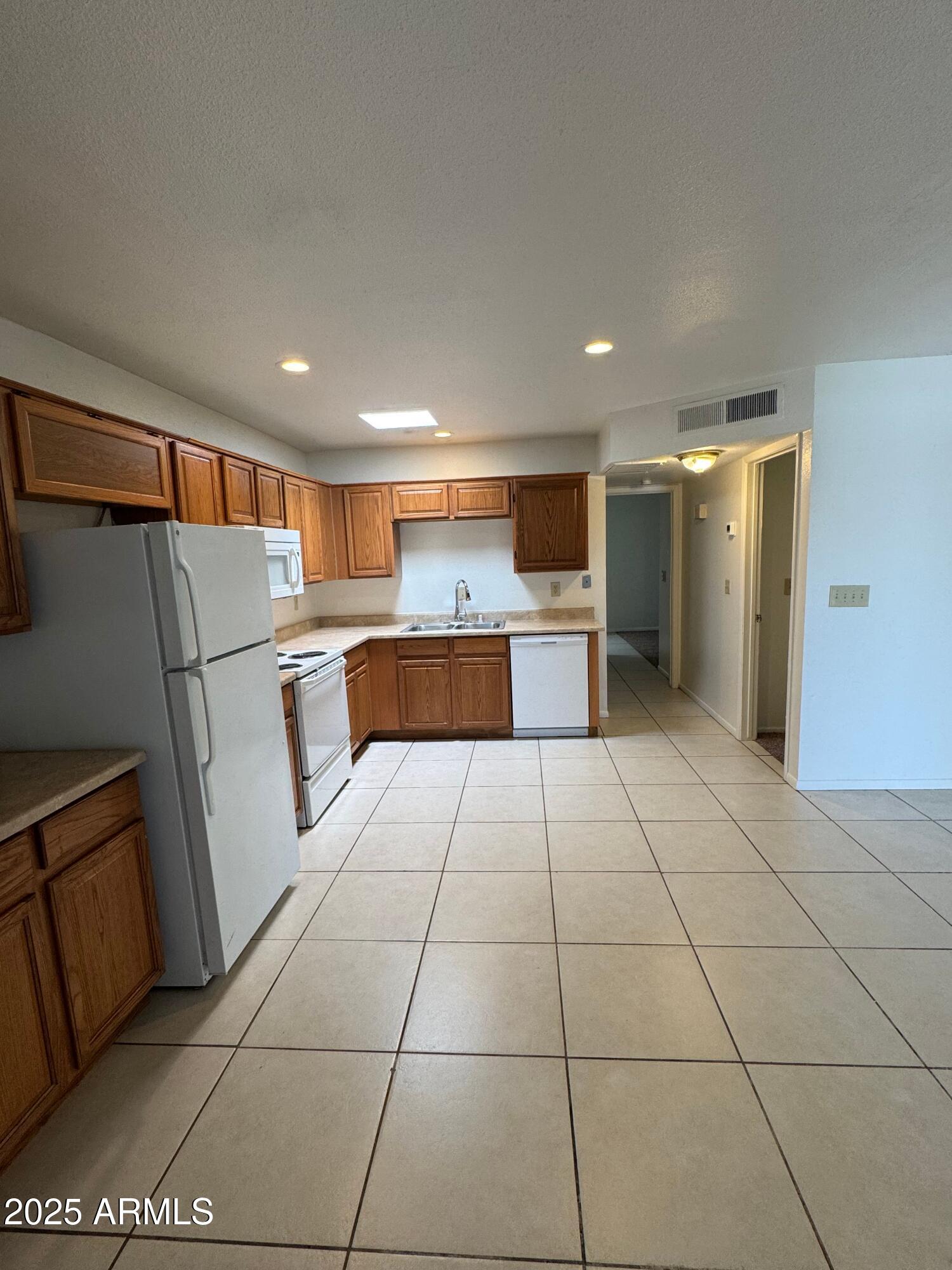 930 South Dobson Road, Unit 23 Mesa, AZ 85202 - Photo 4 of 13 a kitchen with stainless steel appliances granite countertop a refrigerator and a stove top oven