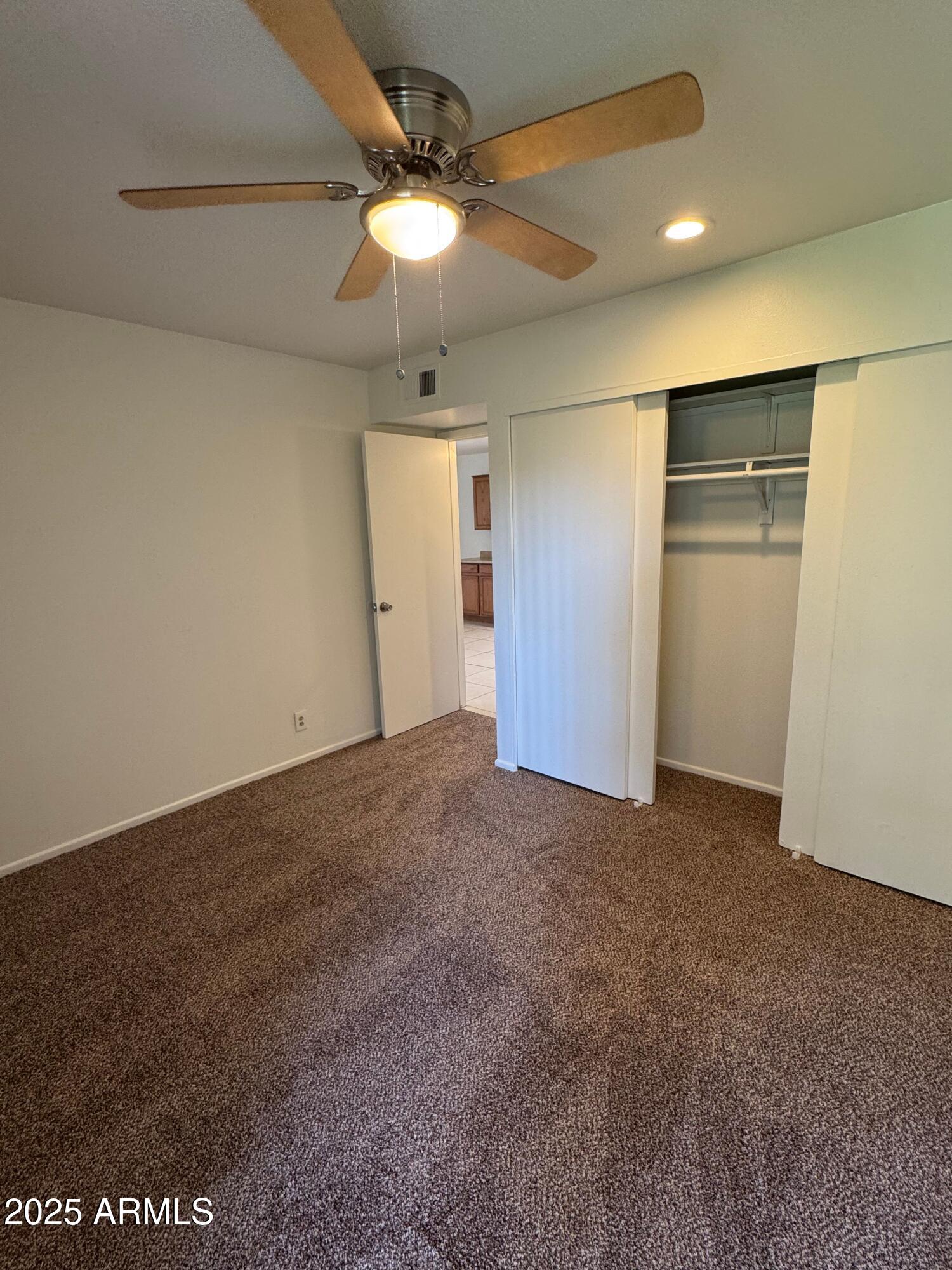 930 South Dobson Road, Unit 23 Mesa, AZ 85202 - Photo 8 of 13 a view of an empty room with a chandelier fan
