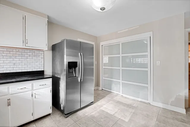 a kitchen with granite countertop a refrigerator and a sink