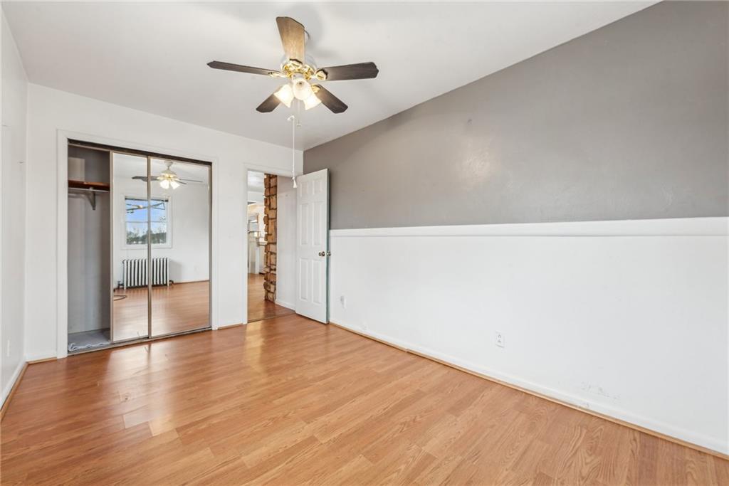 221 Woodside Road Irwin, PA 15642 - Photo 12 of 35 an empty room with wooden floor and a ceiling fan