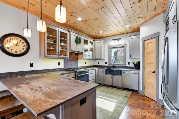 a kitchen with stainless steel appliances granite countertop a sink a stove and a refrigerator