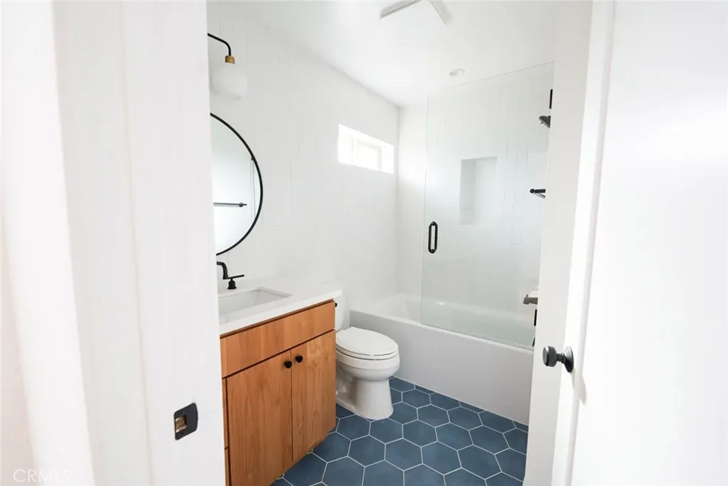 3642 6th Avenue Jefferson Park, CA 90018 - Photo 14 of 26 a bathroom with a granite countertop sink a toilet and shower