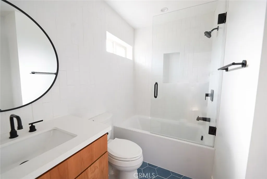 3642 6th Avenue Jefferson Park, CA 90018 - Photo 15 of 26 a bathroom with a sink a toilet and a mirror