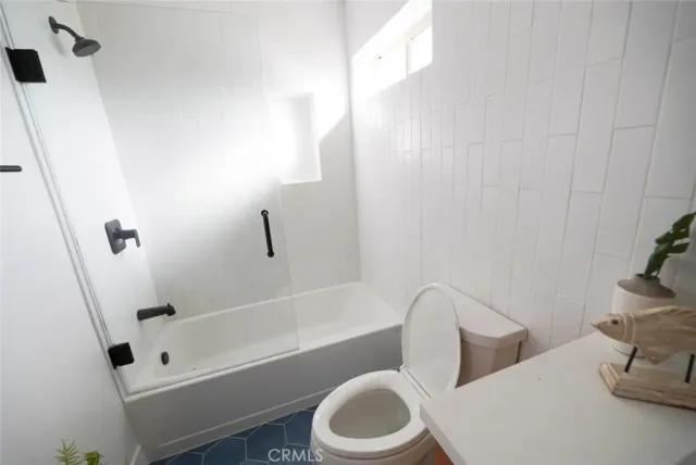a white toilet sitting next to a bath tub