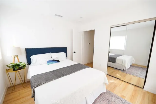 a bedroom with a bed and a potted plant