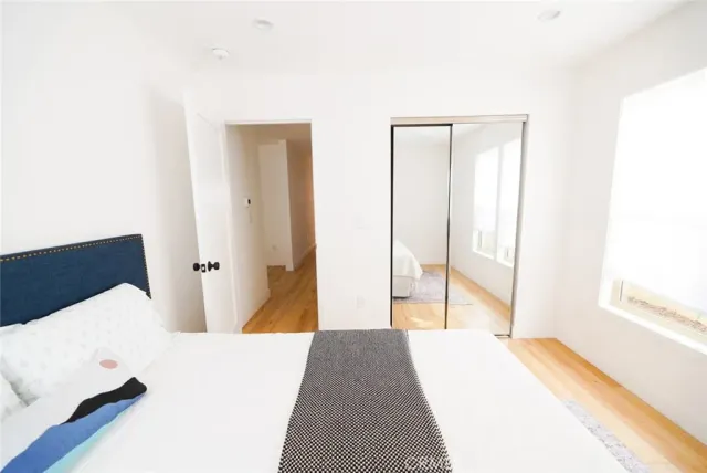 a bedroom with a bed and wooden floor