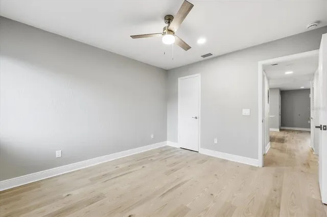 an empty room with fan and entrance