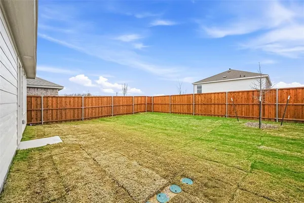 a view of backyard with wooden fence