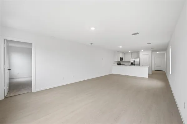 a view of a big room with wooden cabinet and windows