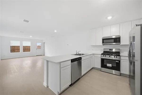 a kitchen with stainless steel appliances granite countertop a stove top oven a sink and dishwasher