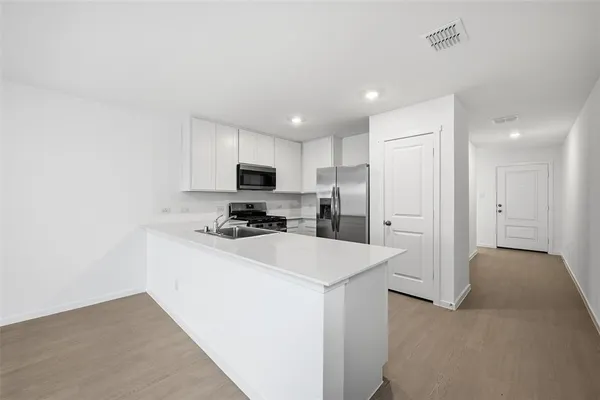a kitchen with stainless steel appliances a refrigerator sink and stove