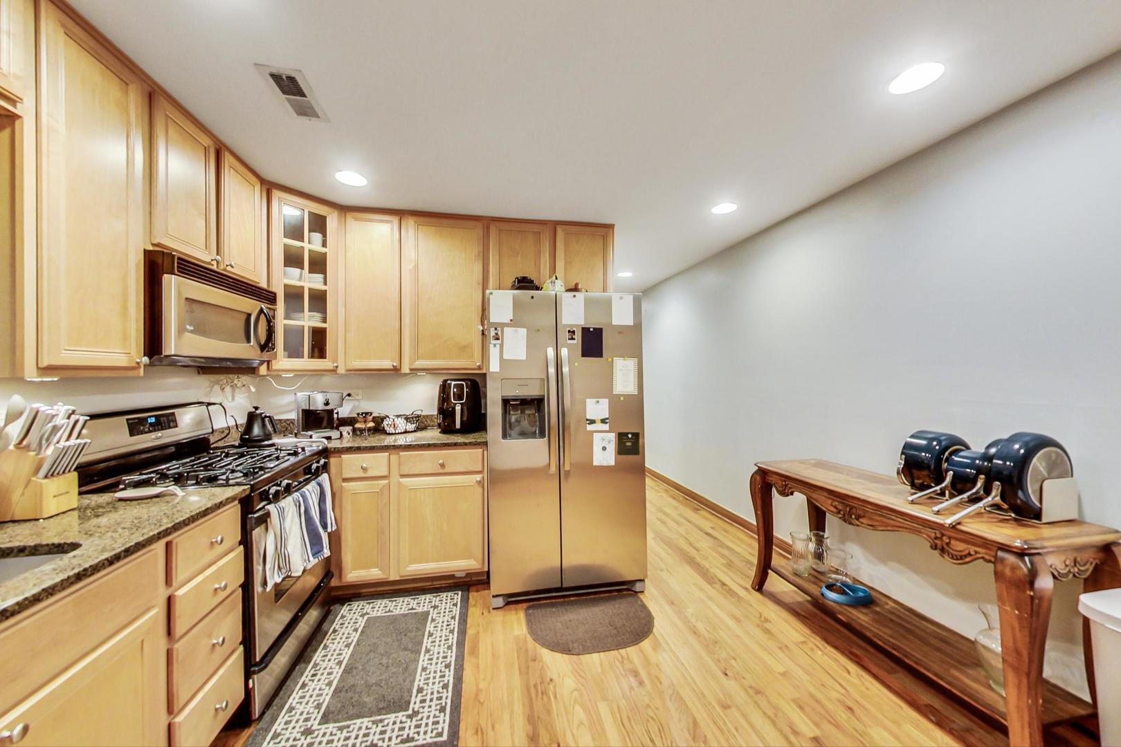 2911 North Talman Avenue, Unit 1 Chicago, IL 60618 - Photo 11 of 21 a kitchen with granite countertop a stove and a refrigerator