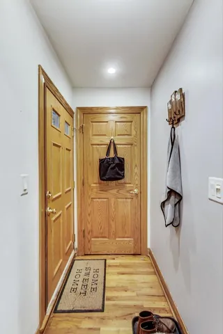 a view of a hallway with a door and wooden floor