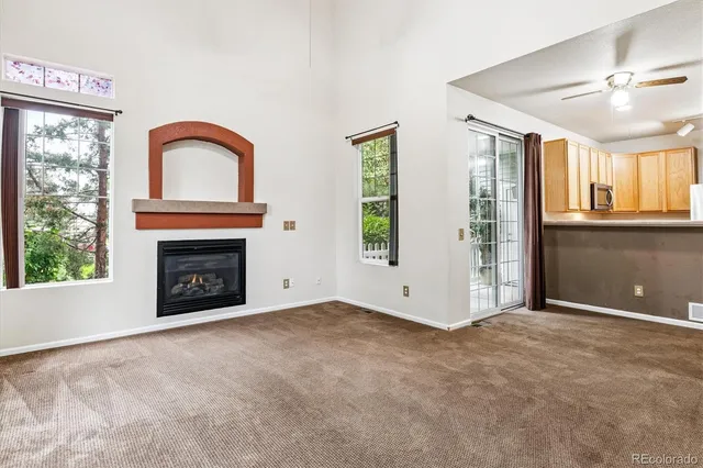 a view of an empty room with a fireplace and a window