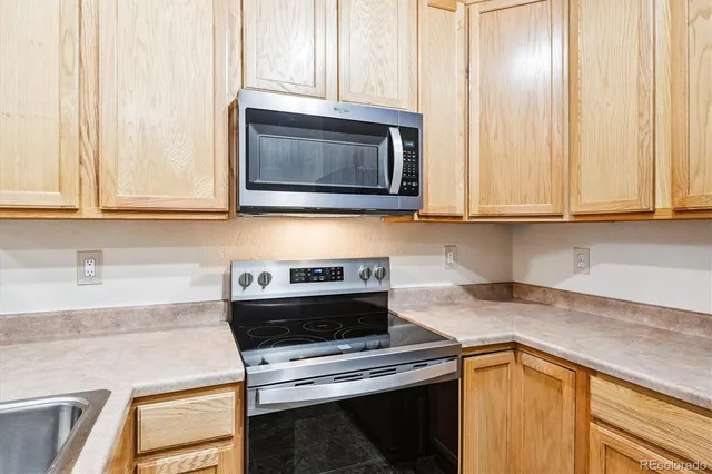 a kitchen with granite countertop cabinets stainless steel appliances and a counter space